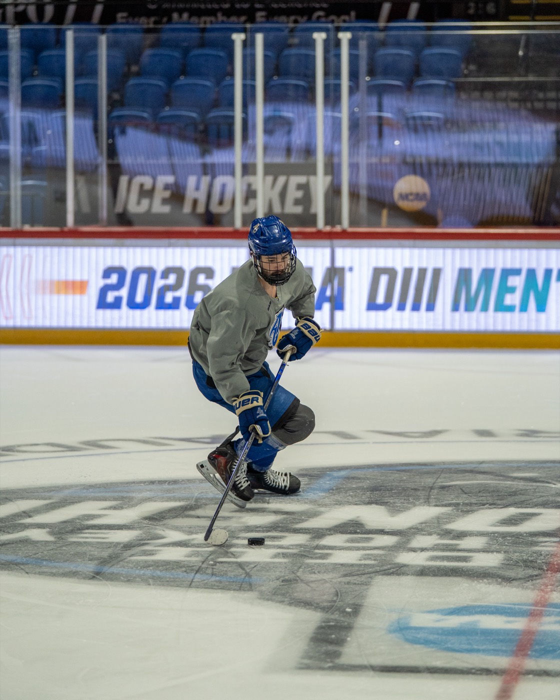 Player skating over the Frozen Four center ice logo