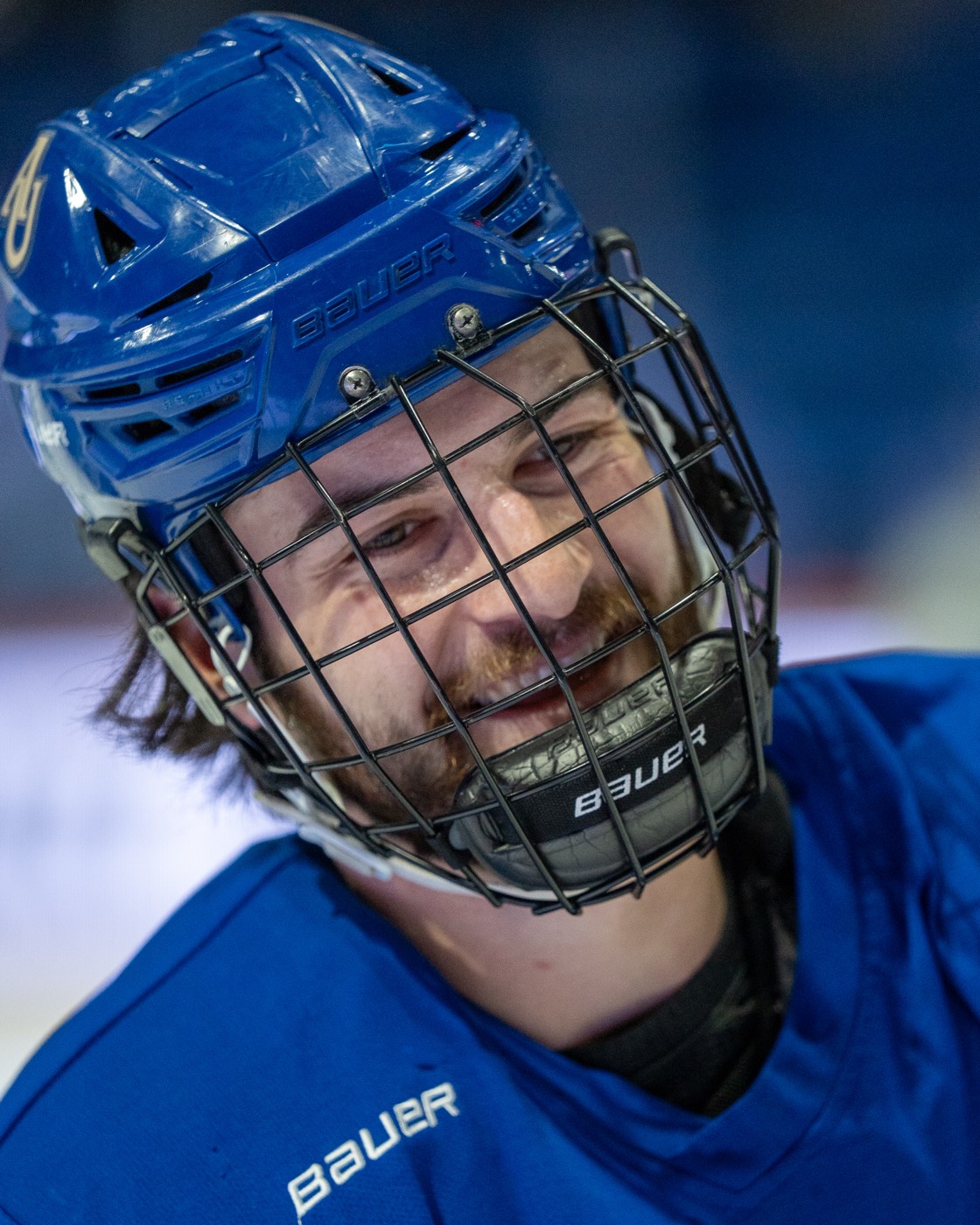 Smiling Aurora hockey player in helmet