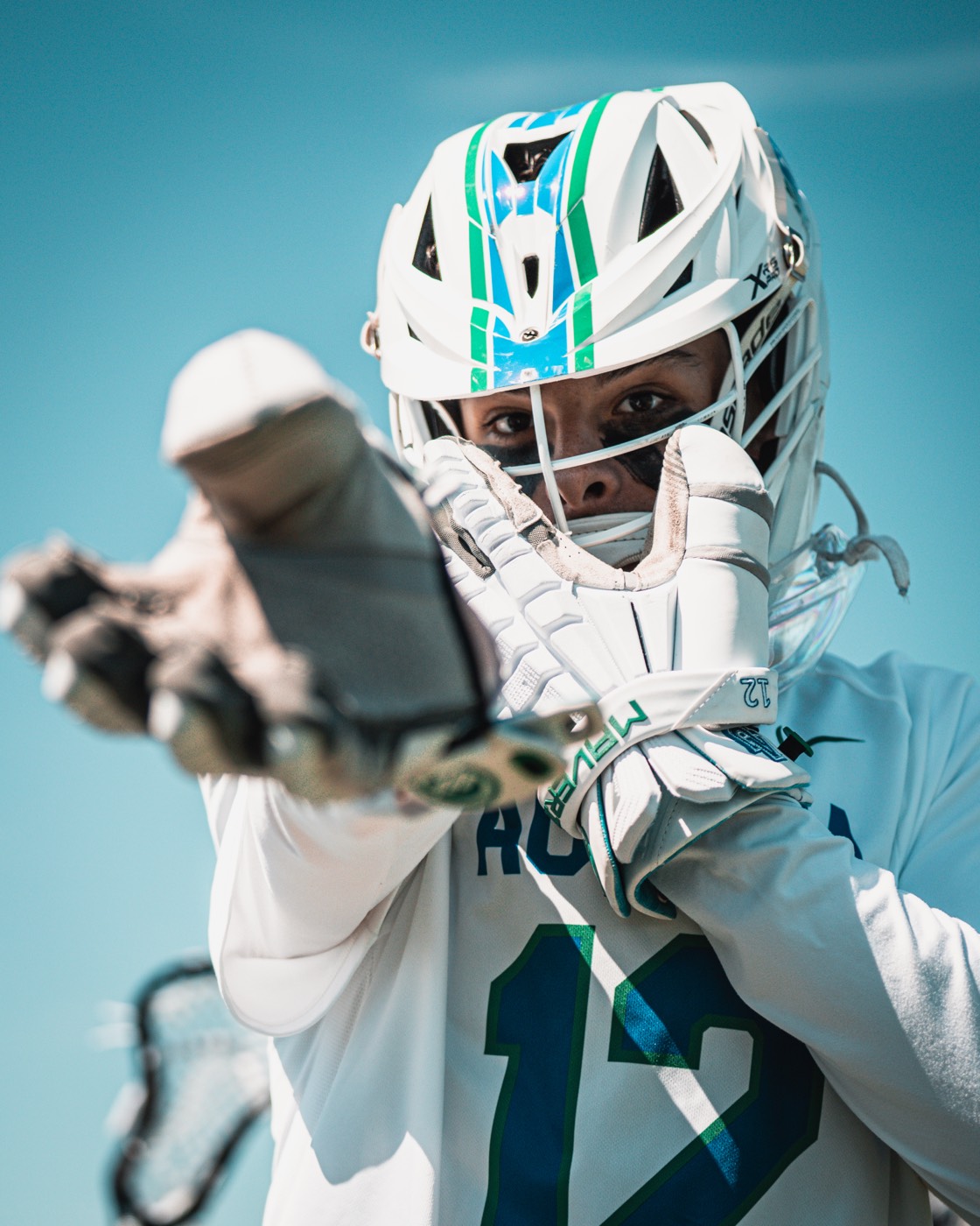Aurora lacrosse player celebrating with a raised stick