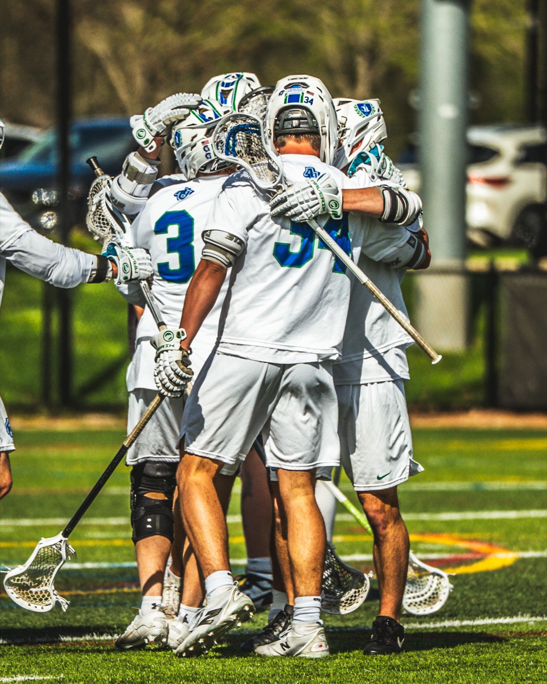 Aurora lacrosse teammates celebrating a goal